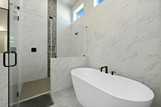 bathroom with tile patterned flooring, shower with separate bathtub, and tile walls