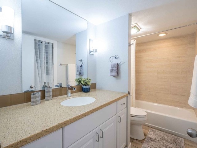 full bathroom with shower / bath combo with shower curtain, hardwood / wood-style floors, toilet, and vanity