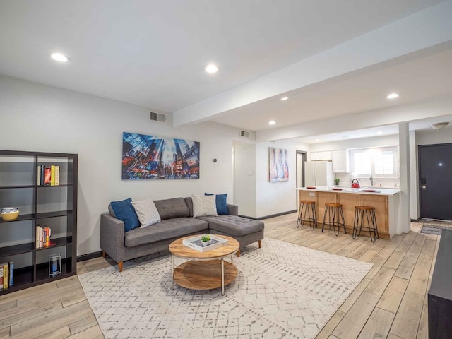 living room with sink and light wood-type flooring