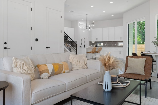 living room with stairs, a chandelier, and recessed lighting