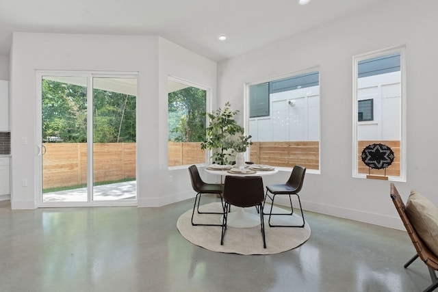 dining space with recessed lighting, finished concrete flooring, and baseboards