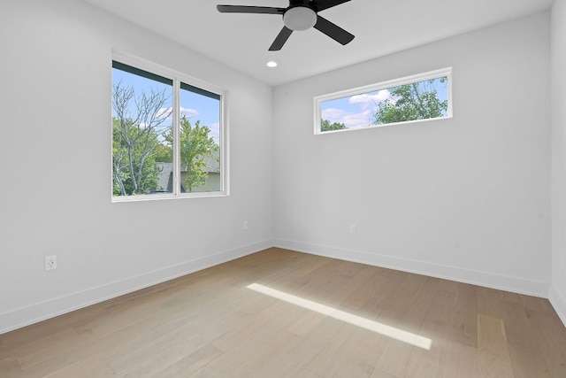 spare room featuring a ceiling fan, recessed lighting, light wood-style flooring, and baseboards