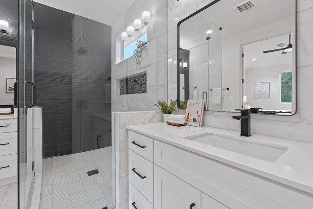 bathroom featuring vanity, a wealth of natural light, ceiling fan, and a shower with door