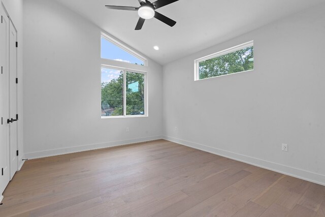 empty room featuring lofted ceiling, ceiling fan, and light wood-type flooring