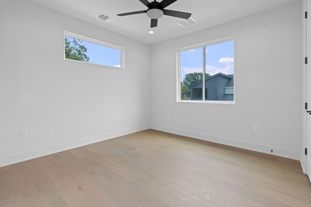 unfurnished room with a wealth of natural light, ceiling fan, and light hardwood / wood-style floors