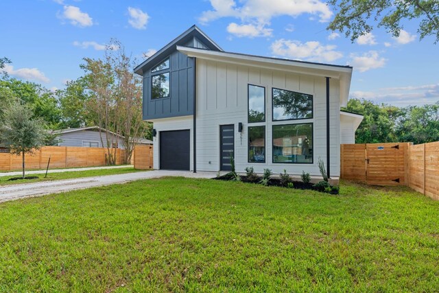 contemporary home featuring a garage and a front lawn