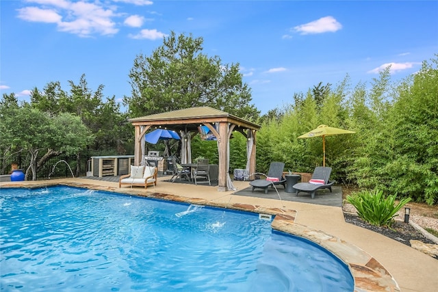 view of swimming pool featuring pool water feature, a patio area, and a gazebo