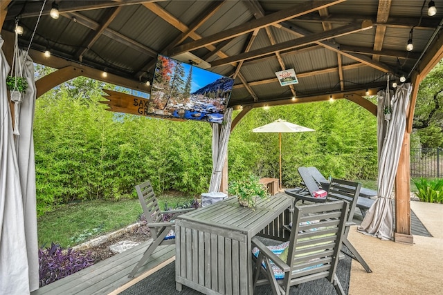 view of patio / terrace with outdoor dining area, a deck, and a gazebo