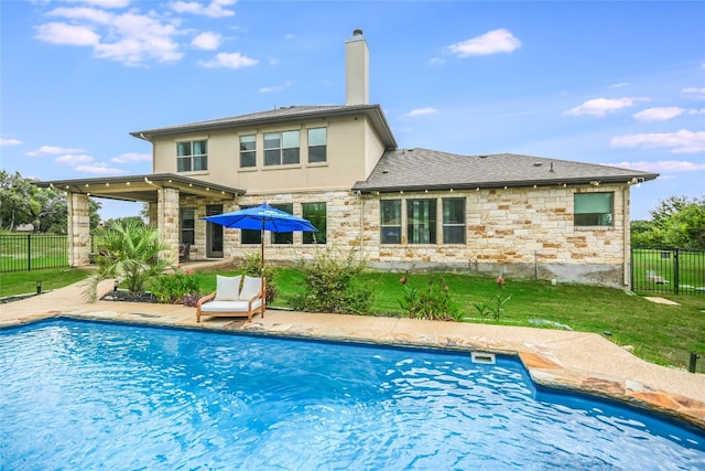 back of house with a fenced in pool, a chimney, stucco siding, fence, and stone siding