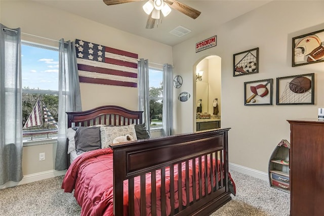 bedroom featuring ensuite bathroom, carpet flooring, a ceiling fan, visible vents, and baseboards