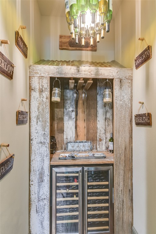 bar featuring a chandelier and wine cooler