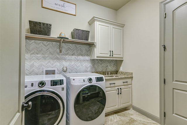 laundry area with washer and clothes dryer, a sink, and cabinet space