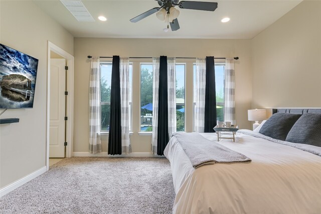 bedroom featuring multiple windows, baseboards, and light colored carpet