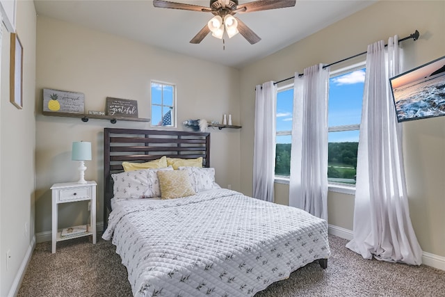 bedroom with dark carpet, a ceiling fan, and baseboards