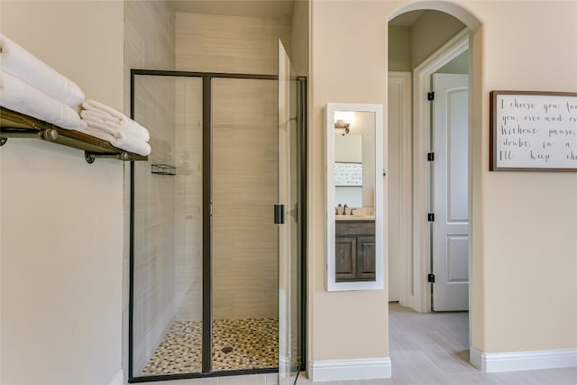 bathroom featuring a shower with door, vanity, and wood-type flooring