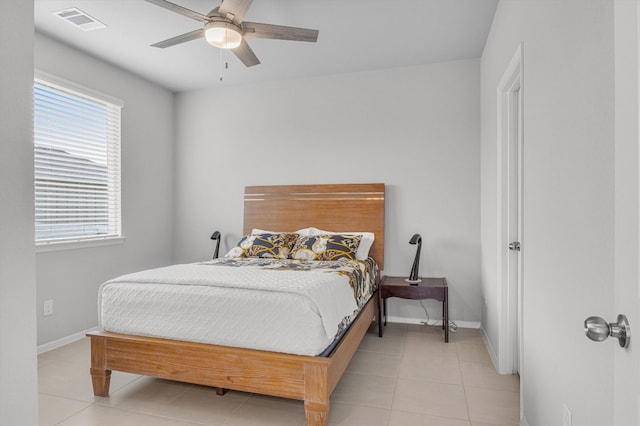 tiled bedroom featuring multiple windows and ceiling fan