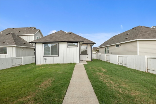 rear view of property with a yard