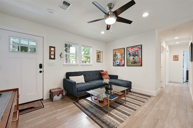 living room featuring light hardwood / wood-style flooring and ceiling fan