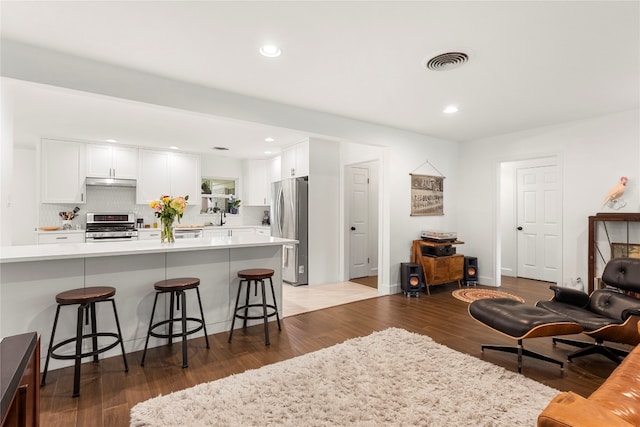 living room with hardwood / wood-style floors and sink