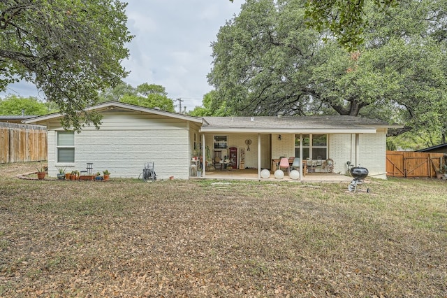 rear view of property featuring a lawn and a patio