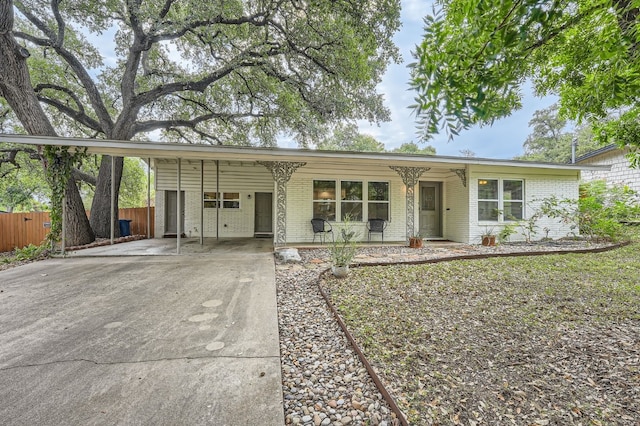 ranch-style home featuring covered porch and a carport