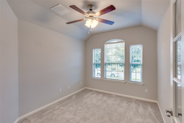 carpeted empty room with a wealth of natural light, ceiling fan, and vaulted ceiling