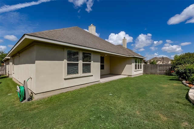 rear view of house featuring a yard