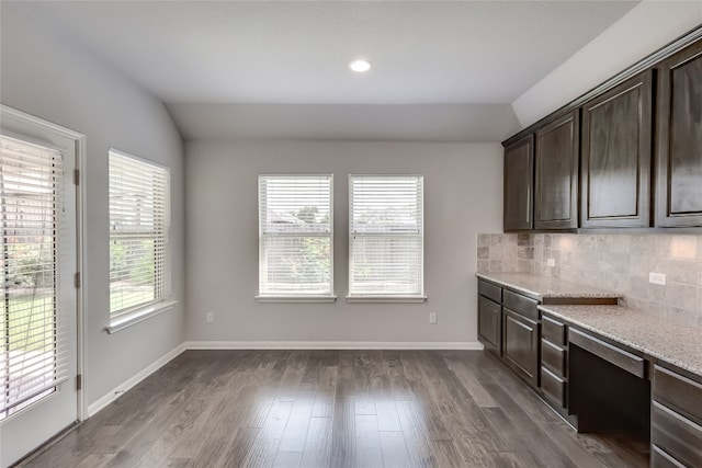 interior space with lofted ceiling, dark hardwood / wood-style flooring, and built in desk