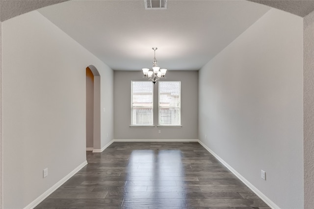 unfurnished room featuring dark hardwood / wood-style floors and an inviting chandelier