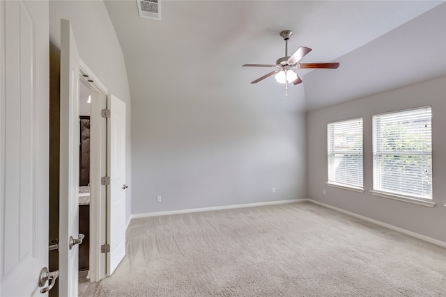 carpeted empty room featuring vaulted ceiling and ceiling fan