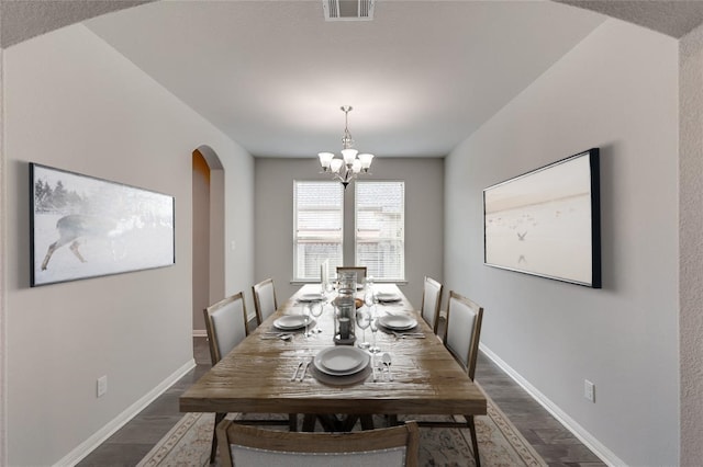 dining space featuring dark hardwood / wood-style floors and a notable chandelier