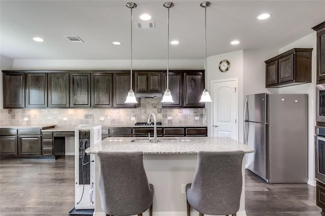 kitchen featuring decorative light fixtures, dark hardwood / wood-style flooring, dark brown cabinetry, and appliances with stainless steel finishes