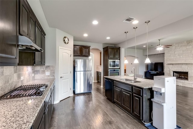 kitchen with hanging light fixtures, sink, dark hardwood / wood-style floors, appliances with stainless steel finishes, and dark brown cabinets