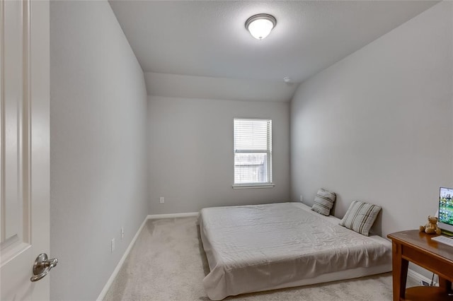 carpeted bedroom featuring lofted ceiling