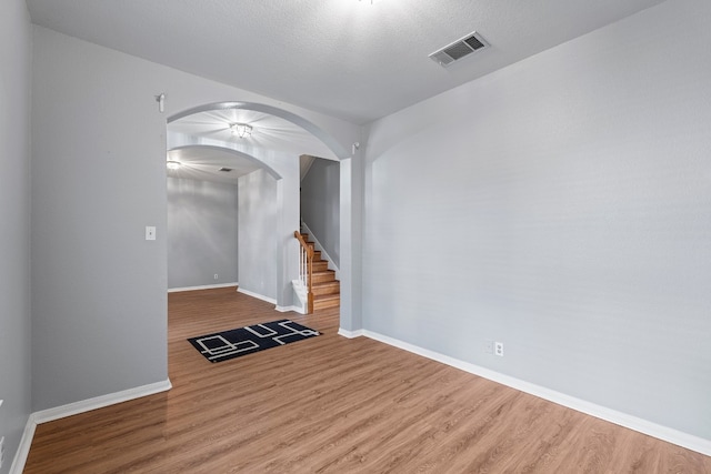 unfurnished living room featuring hardwood / wood-style flooring and a textured ceiling