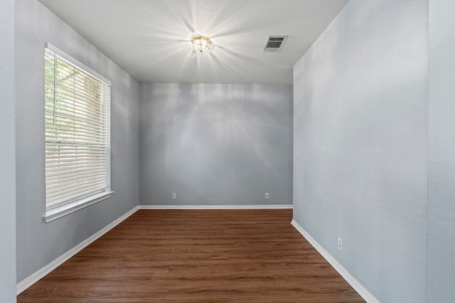 unfurnished room with dark wood-type flooring