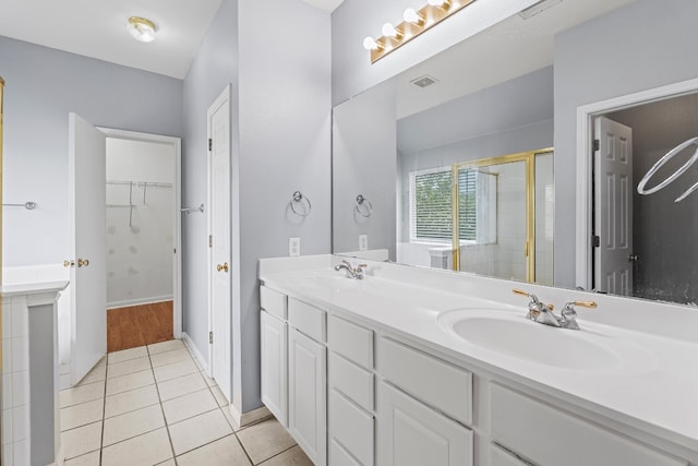 bathroom with tile patterned flooring, vanity, and a shower with shower door