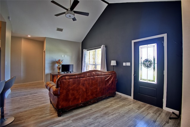 living room with high vaulted ceiling, ceiling fan, and light hardwood / wood-style flooring