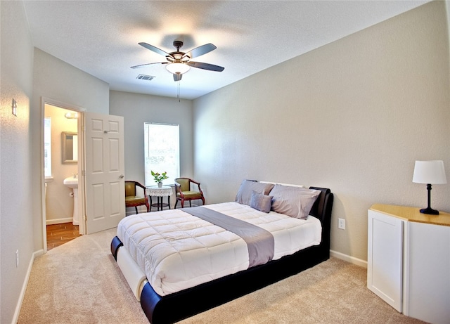 carpeted bedroom featuring a textured ceiling, ceiling fan, and connected bathroom