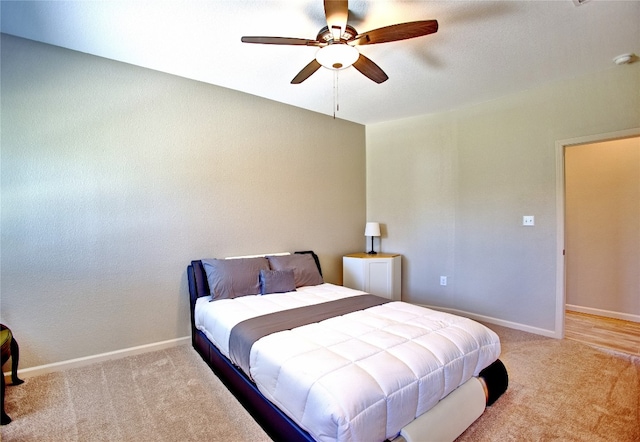 bedroom with ceiling fan and light carpet