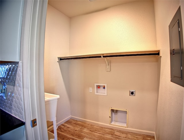 laundry area with light wood-type flooring, washer hookup, electric panel, and hookup for an electric dryer