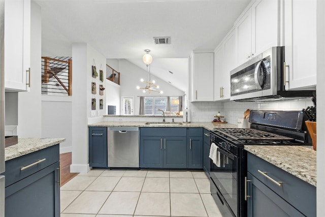 kitchen featuring white cabinetry, a chandelier, sink, appliances with stainless steel finishes, and lofted ceiling