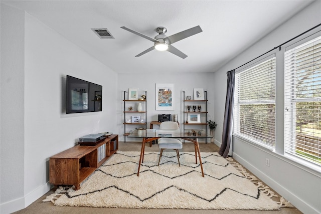 carpeted office featuring ceiling fan