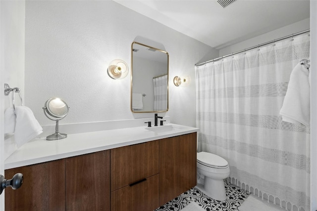 bathroom with vanity, toilet, and tile patterned floors