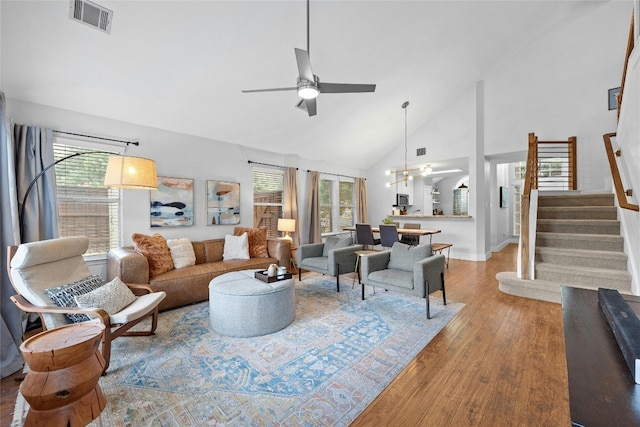 living room with high vaulted ceiling, ceiling fan, and light hardwood / wood-style floors