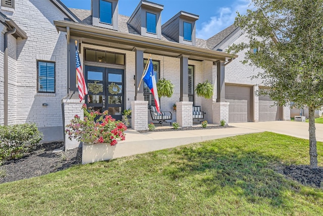 view of front facade featuring covered porch, a front yard, and a garage