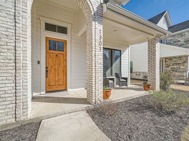 view of exterior entry featuring covered porch