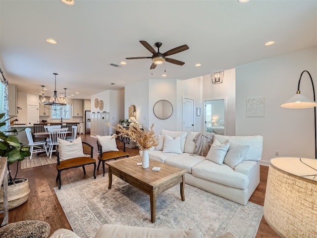 living room featuring light hardwood / wood-style floors and ceiling fan with notable chandelier