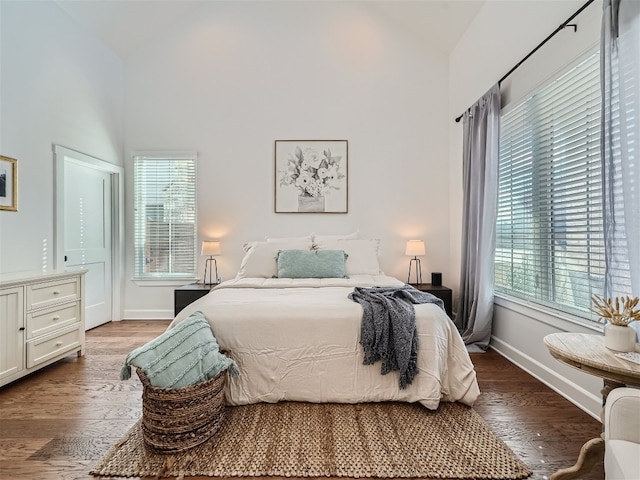 bedroom with multiple windows, wood-type flooring, and vaulted ceiling