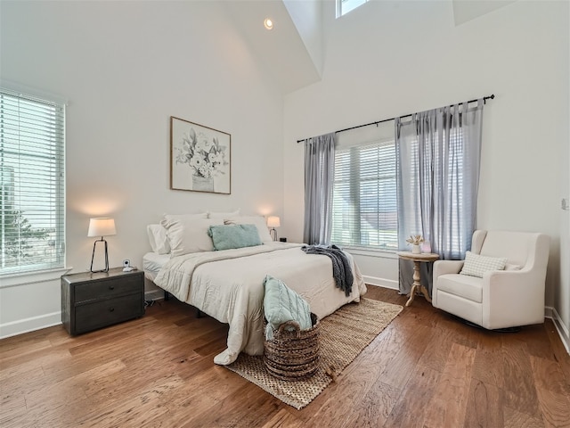 bedroom with wood-type flooring and a high ceiling